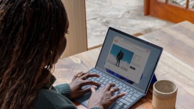 a woman sitting at a table using a laptop computer